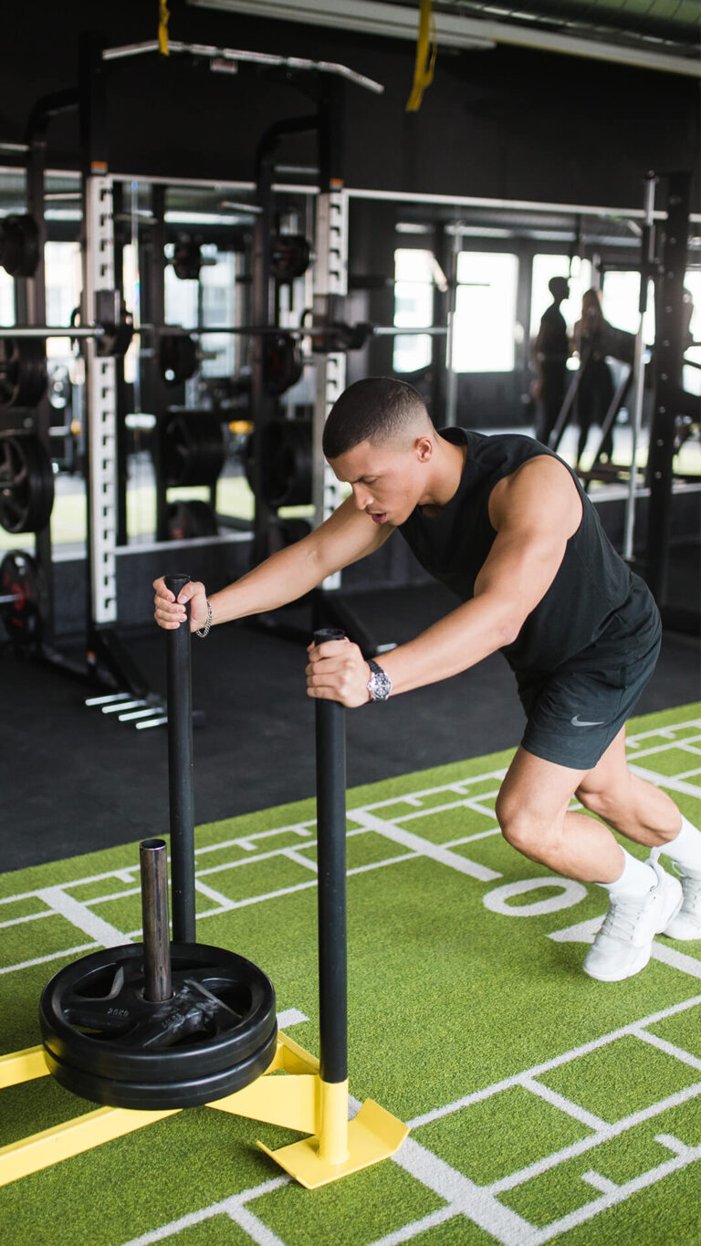 Member pushing a weighted sled at GYMONE