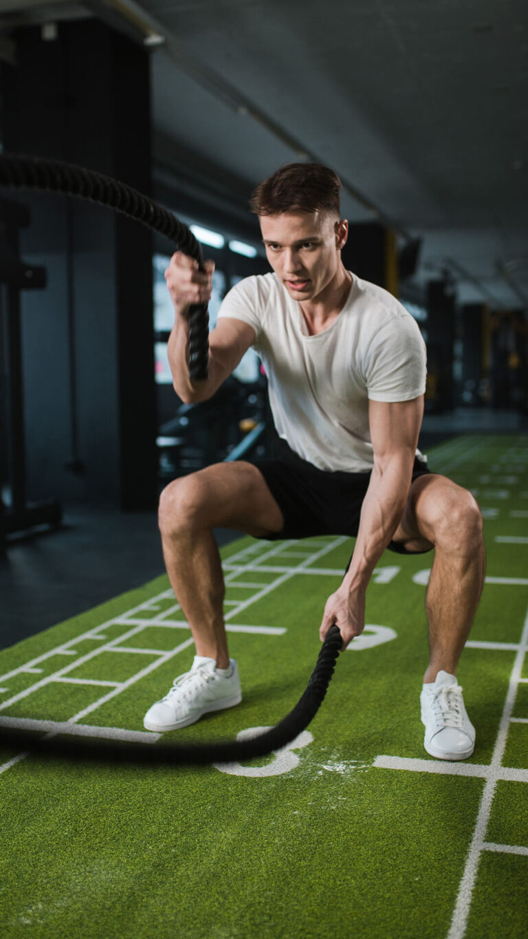 Member training with battle ropes at GYMONE